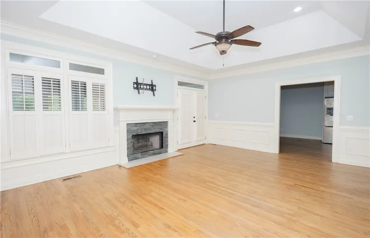 A refined living space showcases beautiful hardwood floors, a classic fireplace, and high vaulted ceilings.