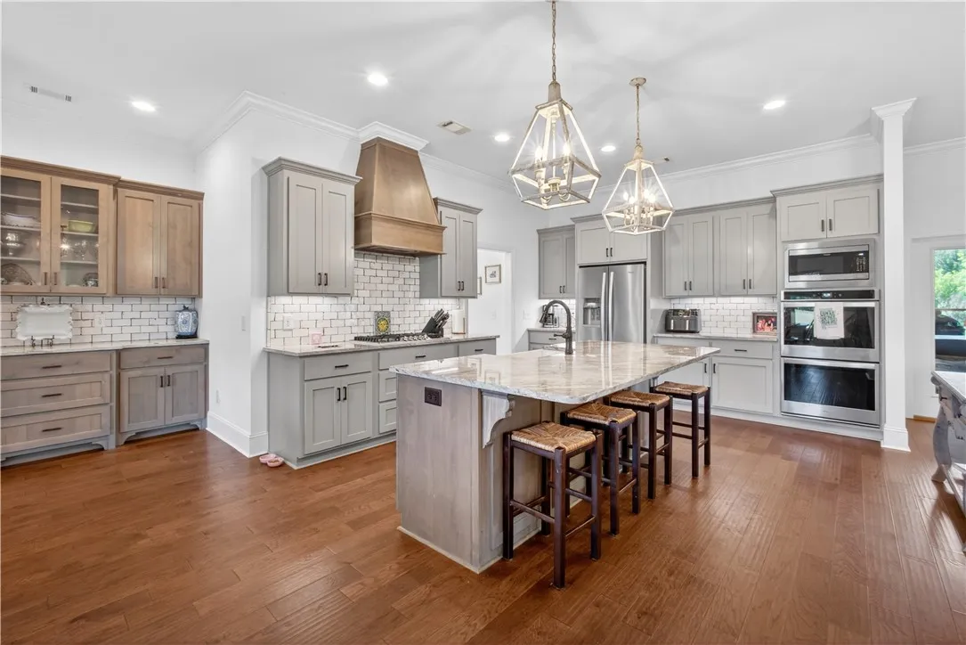 Culinary dreams come alive in this kitchen, featuring an oversized granite island and custom cabinetry.