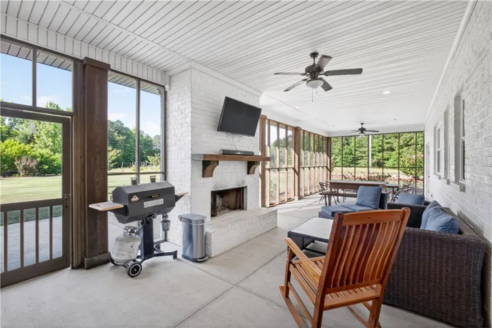 An inviting screened porch offers abundant outdoor living space, featuring a fireplace and scenic views.