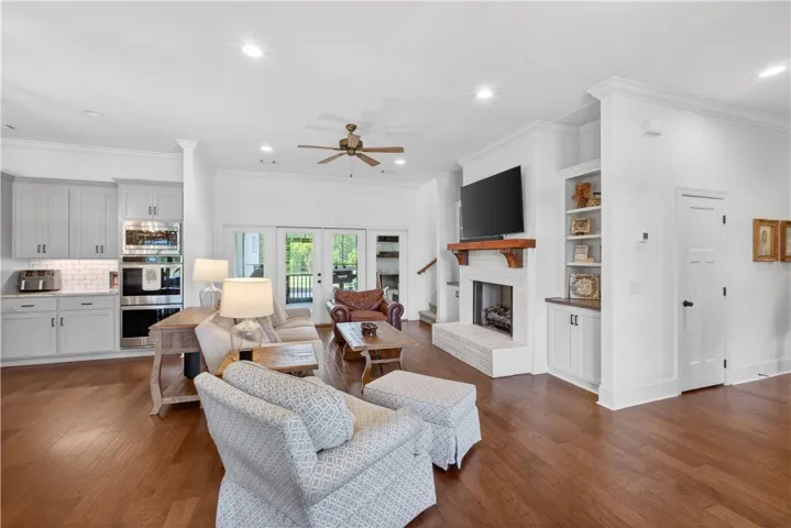 Hardwood floors flow through this sun-filled living space, merging kitchen, dining, and family room with an inviting fireplace.