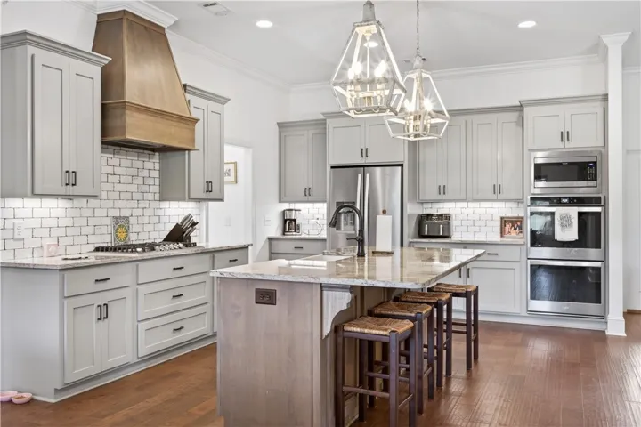Gourmet kitchen offers granite counters, a spacious island, and stainless steel appliances, perfect for hosting.