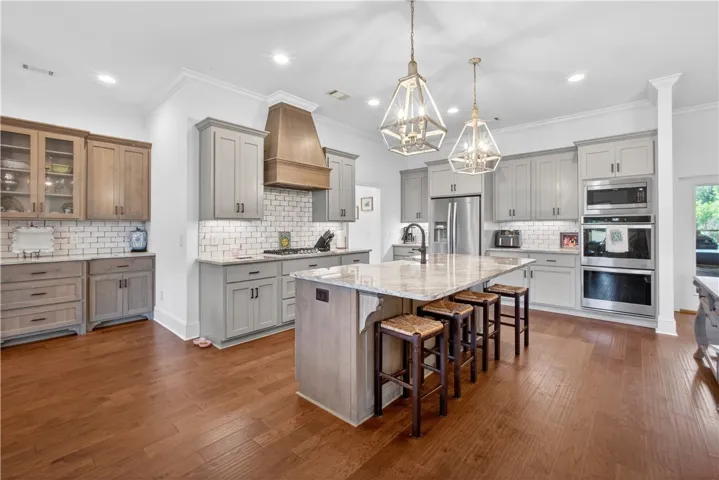 Culinary dreams come alive in this kitchen, featuring an oversized granite island and custom cabinetry.
