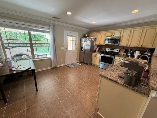 Granite counters and stainless steel appliances outfit this functional, naturally illuminated kitchen space.