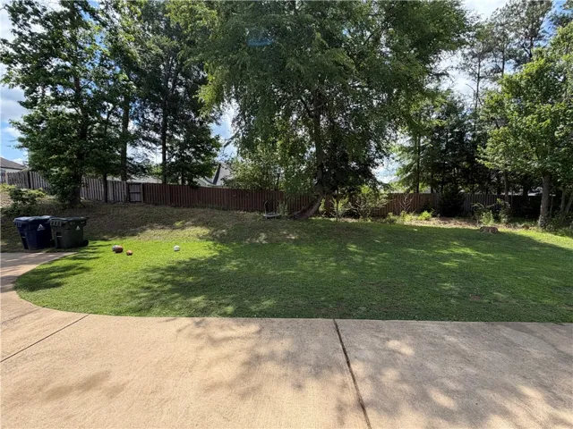 A well-maintained lawn and concrete patio offer ample outdoor space for leisure and recreation.