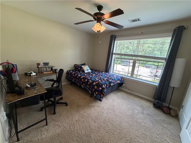 Well-lit sleeping quarters with a generous window overlooking green surroundings.