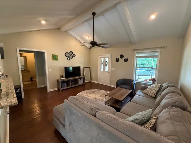 A welcoming living area showcases elegant hardwood flooring and lofty vaulted ceilings.