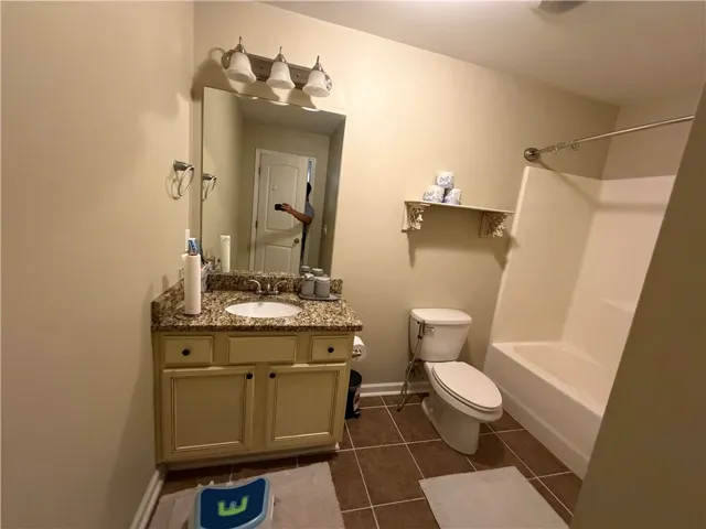 Functional full bathroom featuring a tub-shower combination, a vanity with granite counters, and tile flooring.