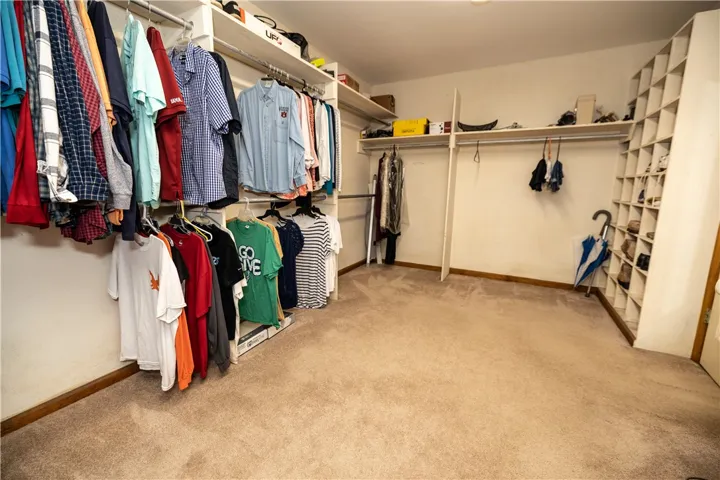 Ample built-in storage and hanging rods organize a well-appointed walk-in closet.