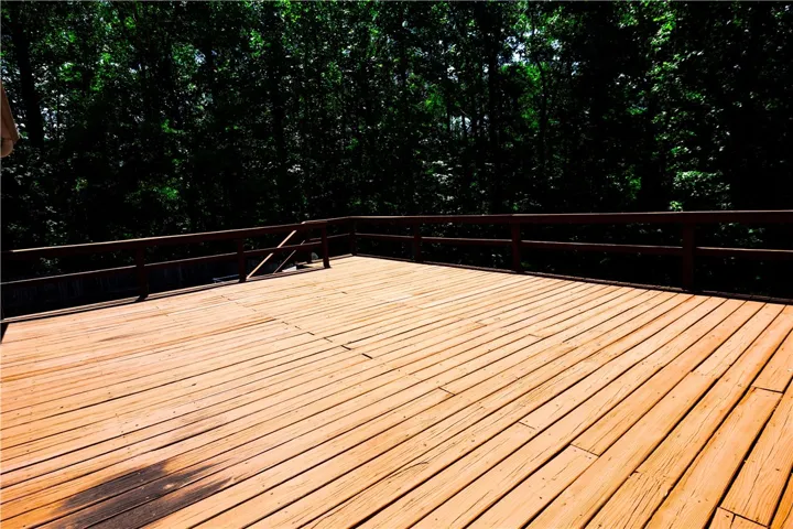 A spacious wooden deck provides a private outdoor retreat with verdant treetop views.