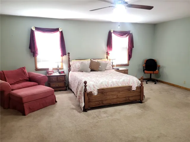 A spacious bedroom offers a tranquil retreat with soft carpeting and ample natural light.