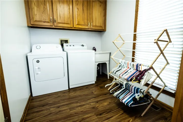 Functional laundry room offers a convenient sink, full-size appliances, and ample cabinet storage.
