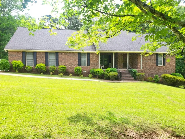 A classic brick exterior, framed by a generous lawn, offers a welcoming facade with a covered entry.