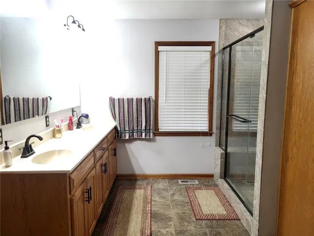 A well-appointed bath features a spacious vanity with dual sinks and a large walk-in shower.