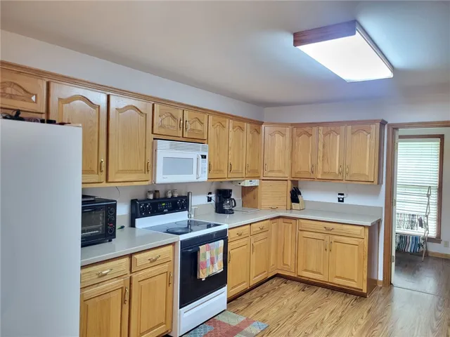Functional kitchen with ample cabinetry and essential appliances awaits your culinary touch.