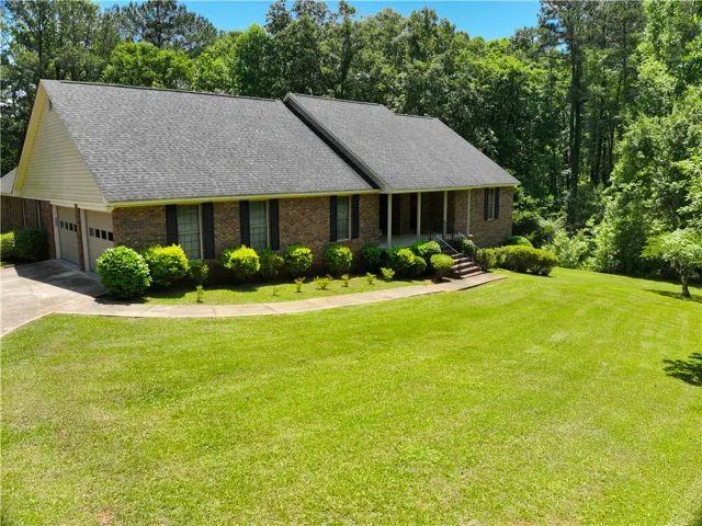 A classic brick exterior, lush green lawn, and integrated garage create inviting curb appeal.