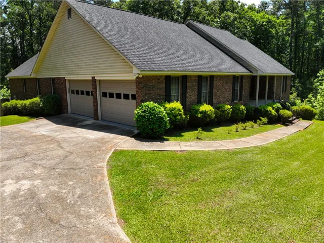 A classic brick exterior, inviting with its integrated garage and well-maintained grounds.
