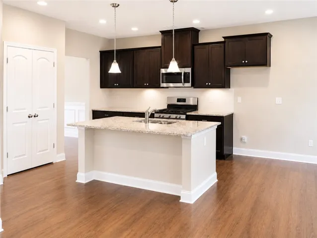 The kitchen offers granite counters, an island, gas stove, pantry, and a breakfast space.