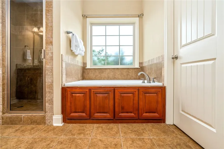 Indulge in a tranquil bathing experience within this well-appointed bathroom featuring a soaking tub and separate shower.
