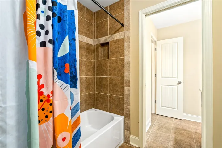 A well-appointed bath features a tiled shower and tub combination, offering a clean and functional space.