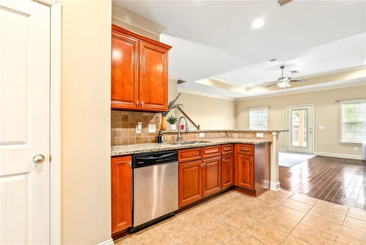 Granite counters and stainless steel appliances complete this contemporary kitchen, offering open sightlines to the adjacent living area.