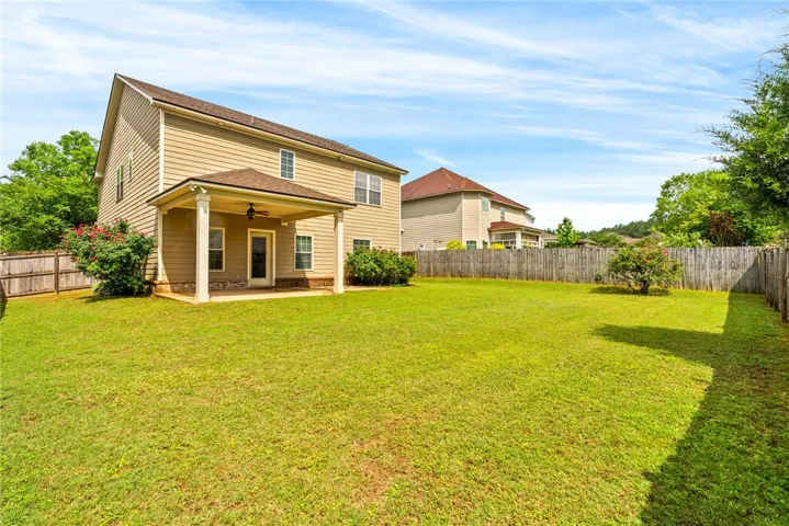 A deep backyard with a covered patio offers ample space for outdoor enjoyment.