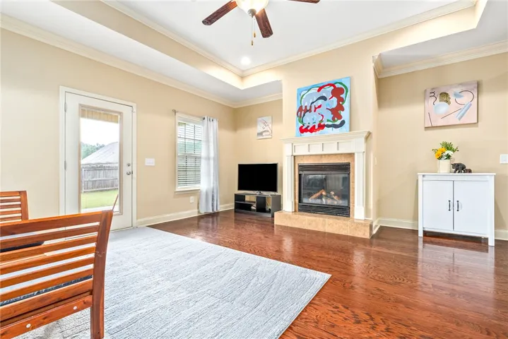 Rich hardwood floors complement a cozy fireplace, perfect for gatherings in this inviting living space.