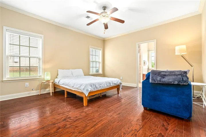 Hardwood floors and a gentle ceiling fan create a peaceful, well-lit sanctuary.