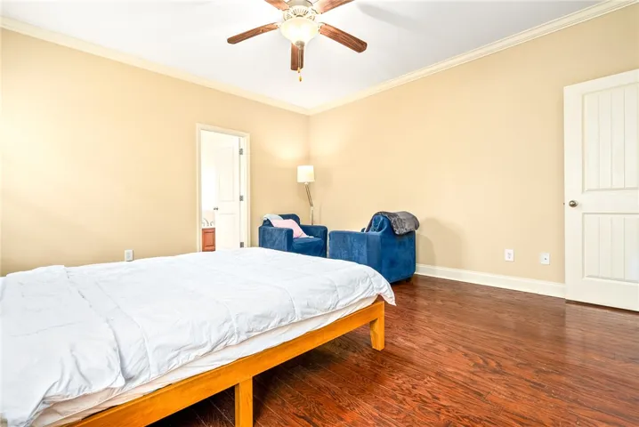 Rich hardwood floors create a welcoming atmosphere in this comfortable bedroom space.