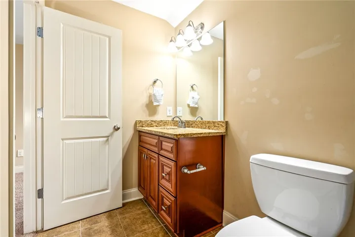 Corner vanity with granite counters and tiled floors create a welcoming bath.