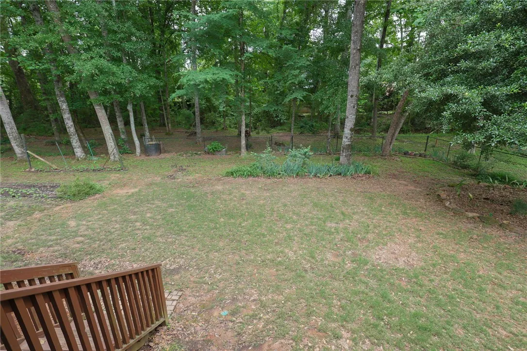 A verdant backyard with mature trees and ample green space invites outdoor enjoyment.