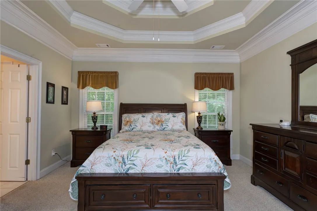 An inviting room with a decorative tray ceiling and neutral-toned walls.