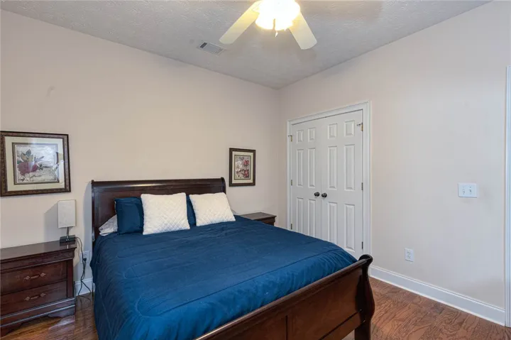 Rich hardwood flooring complements this inviting bedroom space, complete with convenient closet access.