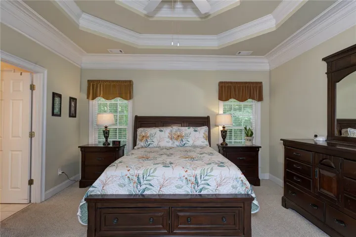 An inviting room with a decorative tray ceiling and neutral-toned walls.