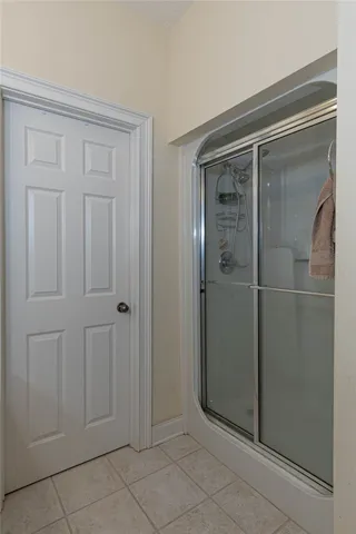 Step into a refreshing bathroom with a classic white six-panel door and a sleek, modern glass-enclosed shower.
