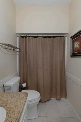 Functional bathroom features a clean commode with a convenient shower enclosure.