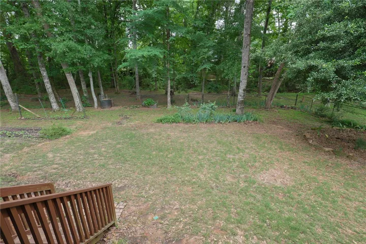 A verdant backyard with mature trees and ample green space invites outdoor enjoyment.