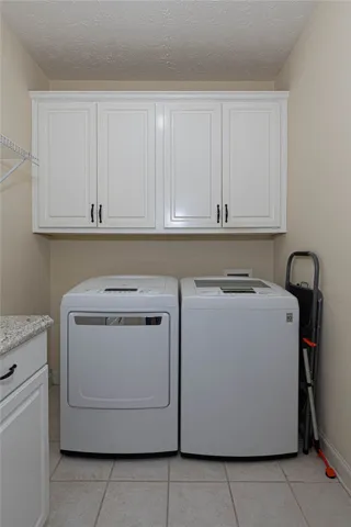 Ample storage options complement efficient laundry appliances in this dedicated utility space.