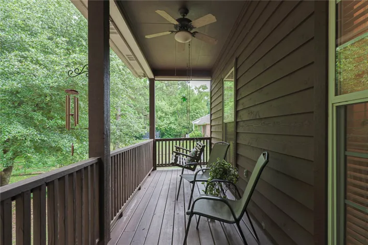 A spacious covered porch offers a tranquil retreat with verdant views and ample relaxation space.