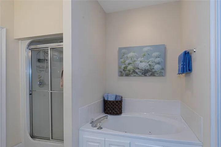 Relaxation awaits in this well-appointed bathroom featuring a jetted tub and a convenient standing shower.