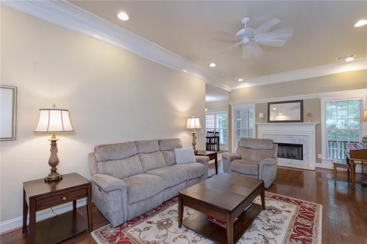 Hardwood floors and a welcoming fireplace create an inviting atmosphere in this well-lit living room.