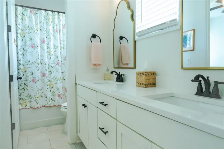 Dual vanity with bright white countertops, offering ample space and contemporary fixtures.