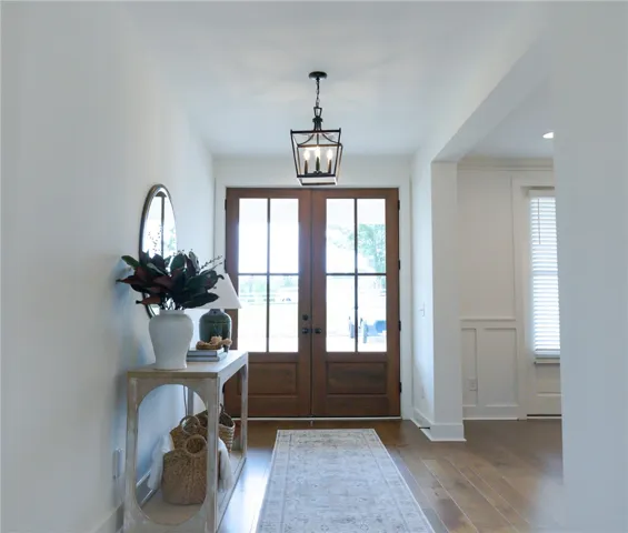 Rich hardwood floors welcome you into this elegant foyer, featuring a charming lantern chandelier.