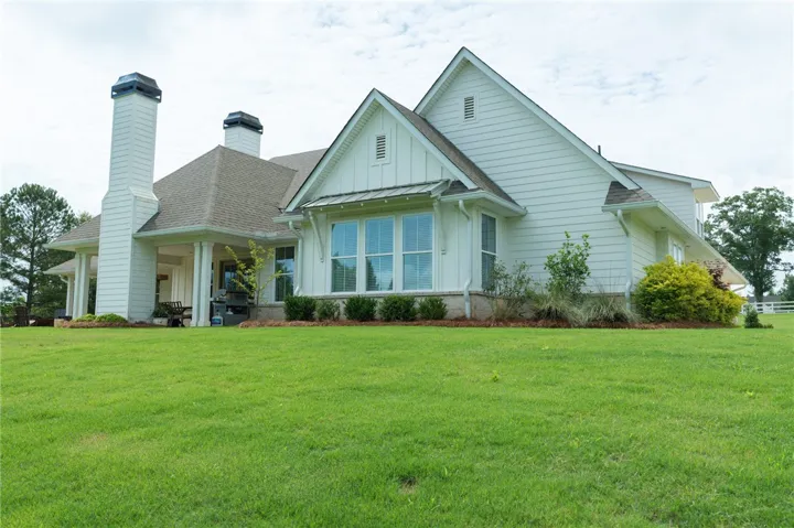 White siding with a welcoming porch and vibrant green yard for delightful outdoor living.