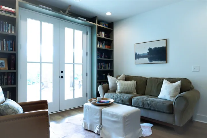 French doors open to an inviting living area framed by built-in shelving.
