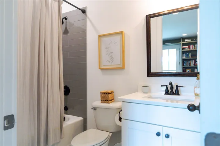A pristine bathroom features a modern vanity and a sleek shower with subway tile.