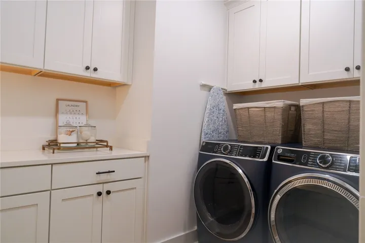 Ample storage and modern appliances elevate this functional and organized laundry room.
