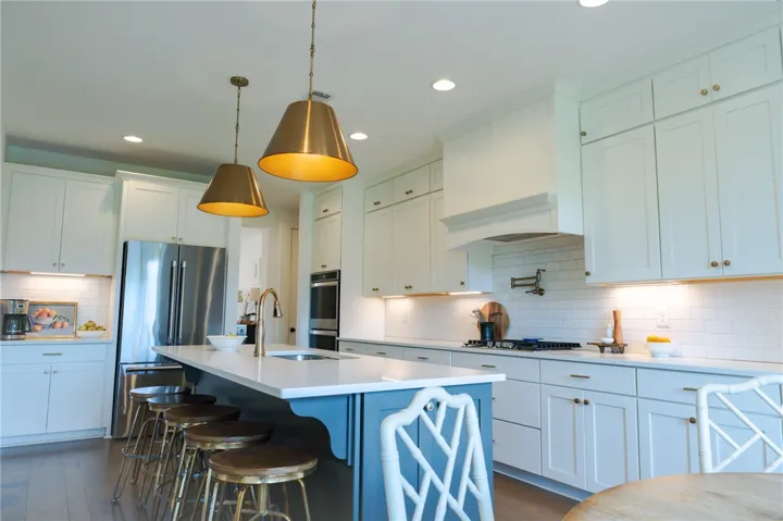 Culinary dreams come alive in this kitchen featuring an island with breakfast bar seating and pendant lighting.