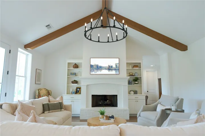 Exposed wood beams accentuate the soaring vaulted ceiling in this inviting living area.