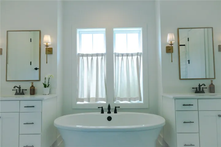 A spacious primary bath offers a serene retreat with dual vanities and a freestanding tub.
