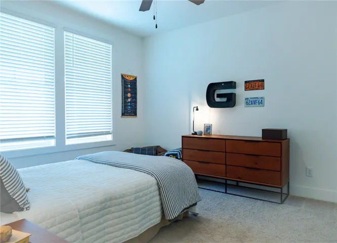 Natural light filters into this carpeted bedroom, offering comfort and ease.